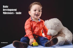 A smiling baby with a teddy bear